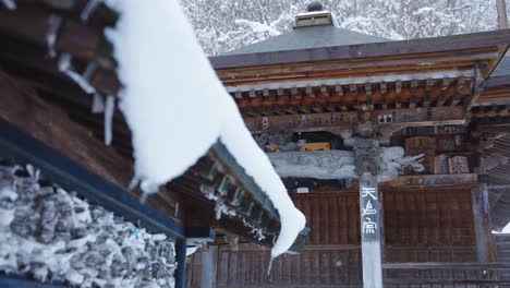 Snowflakes-falling-over-Japanese-Temple,-Yamadera-Shrine-in-Yamagata-Prefecture