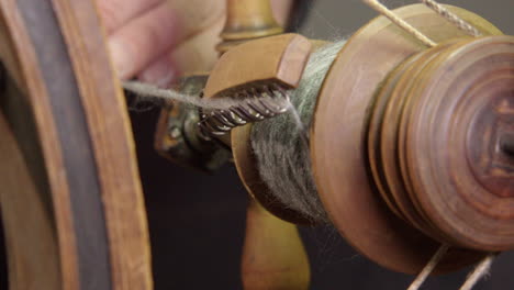 Closeup-detail:-Hand-wraps-wool-yarn-on-Nordic-spinning-wheel-bobbin