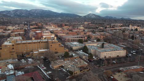 Santa-Fe,-New-Mexico-USA,-Aerial-View-of-Downtown-Buildings-and-Streets-on-Cloudy-Winter-Day,-Drone-Shot