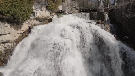 Rushing-waterfall-at-Owen-Sound,-Ontario-with-lush-rocky-surroundings-in-daylight