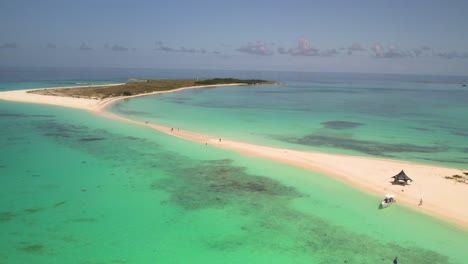 A-serene-sandy-pass-at-cayo-de-agua,-clear-turquoise-waters-with-a-few-visitors,-aerial-view