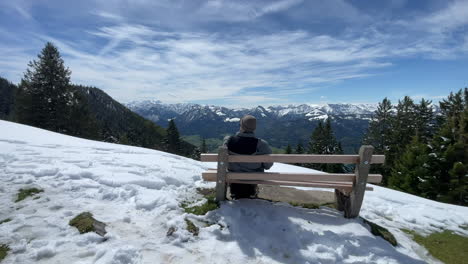 Tourist-sitting-on-bench-after-hiking-on-top-of-Schafsberg-in-Austria,-Salzkammergut-Sankt-Wolfgang