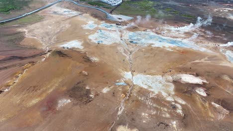 Aerial-View-of-Geothermal-Area-in-Landscape-of-Iceland,-Geysir-Hot-Springs,-Vapors-and-People,-Drone-Shot