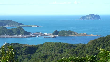 Panoramic-panning-shot-capturing-the-beautiful-landscape-of-Shen'ao-fishing-harbor-and-Keelung-Islet-from-Jiufen-mountain-town-at-daytime,-Ruifang-district,-New-Taipei-City,-Taiwan