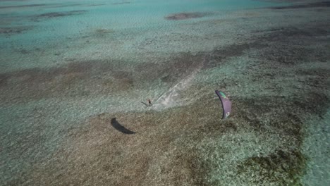 Ein-Kitesurfer-Gleitet-über-Klares-Wasser-Auf-Die-Kamera-Zu,-Luftaufnahme