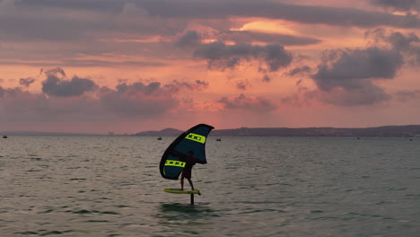 Ala-De-Windsurf-Frustrando-Un-Cielo-Rosado-Del-Atardecer-Sobre-La-Bahía-De-Mui-Ne,-Phan-Thiet,-Vietnam