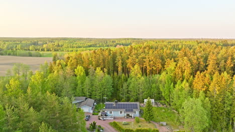 Detached-solar-powered-home-in-middle-of-woods-and-countryside-fields---Aerial-view