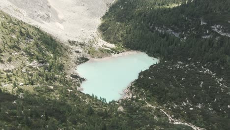 Droneshot-of-a-mountain-lake-in-the-Italian-Alps-with-a-light-blue-milky-water