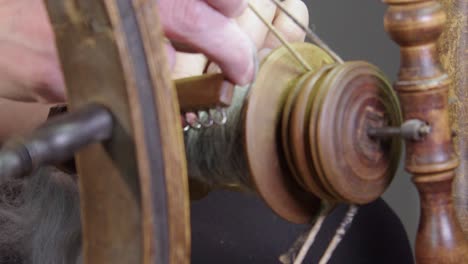 Slo-mo-closeup-detail:-Artisan-hands-with-wool-yarn-on-spinning-wheel