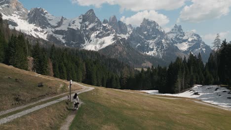 Lone-Woman-Walking-On-The-Trail-Overlooking-Dolomites-Mountain-Range-In-Italy