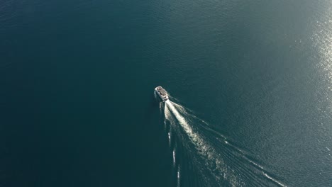 Drone-tracking-footage-of-a-boat-riding-in-redfish-lake-surrounded-by-blue-water