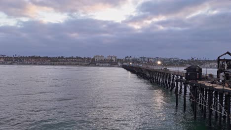 Oceanside-California-Pier-Feuer-Beschädigt-Ehemaliges-Rubys-Diner-Restaurant-Drohne-Seitlicher-Vorbeiflug-Mit-Blick-Aufs-Ufer
