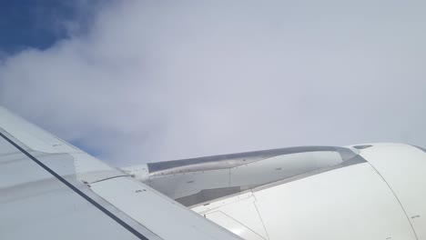 Airplane-Flying-Into-Clouds,-Passenger-Window-POV-Over-Wing-and-Engine