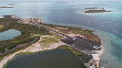 Los-roques-airstrip-with-serene-waters-and-vibrant-greenery-at-dusk,-timelapse,-aerial-view