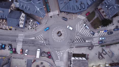 Overhead-dolly-in-flyover-of-a-low-traffic-traffic-circle-in-the-mountain-village-of-Benas-in-the-autonomous-community-of-Aragon,-Spain