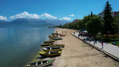 Tranquilo-Paseo-Junto-Al-Lago-En-Pogradec,-Paseo-Marítimo-Del-Lago-Ohrid-Cerca-De-La-Playa,-Con-Barcos-Anclados,-Que-Ofrece-Paseos-Tranquilos-Para-Los-Visitantes
