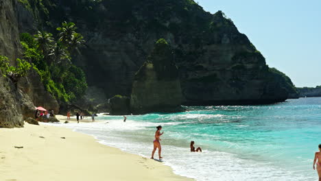 Tourists-enjoying-white-sandy-beach,-tropical-environment,-ocean-water