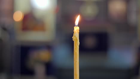 Focus-pull-handheld-shot-of-a-melting-yellow-candle