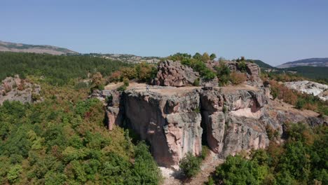 Person-On-Sheer-Rock-Of-Harman-Kaya,-Ancient-Thrace-Rock-Sanctuary-In-Rhodope-Mountain,-Bulgaria
