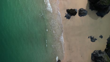 Aerial-Drone-Over-a-Beach-and-Rocks-n-Cornwall-with-Top-Down-View,-UK