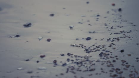 Macro-Night-Time-Water-Crashing-On-Beach-With-Beautiful-Small-Stones