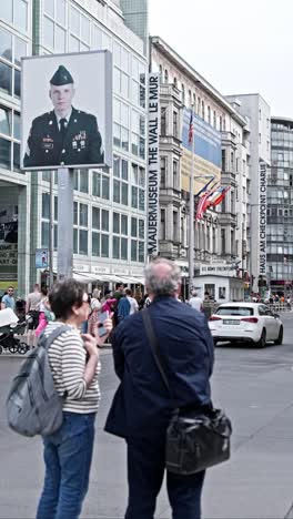 Tourist-Couple-at-Checkpoint-Charlie-Berlin,-Popular-Landmark,-Vertical-Video