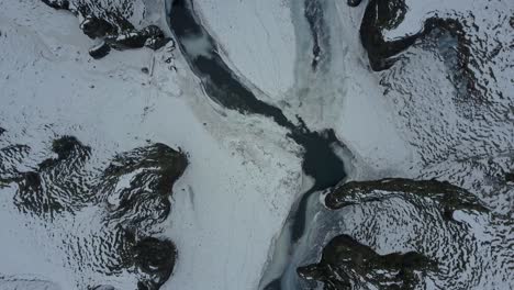Iceland-Rocks-and-Snow-with-River-Flowing-Between-from-an-Aerial-Drone-Top-Down-Shot-Moving-Forward