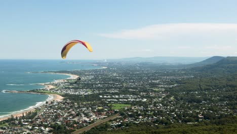 Paraglider-flying-over-beautiful-vast-cityscape-on-sunny-day