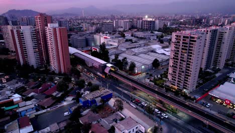 Aerial-view-of-Rodrigo-de-Araya-metro-station-with-Santiago-cityscape-sprawling-in-the-distance,-Chile