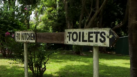 Handheld-view-of-Old-To-Kitchen-and-Toilets-sign-with-arrows-pointing-opposite