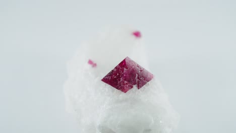 Red-pyramidal-crystal-on-white-ground-rotating