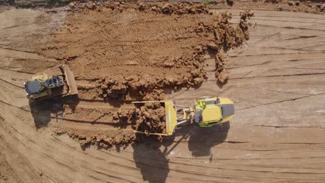 A-bulldozer-and-a-dump-truck-make-short-work-of-fresh-earth-being-distributed-into-a-construction-site