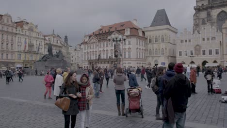 Panning-shot-of-bustling-Old-Town-Square-in-Prague-with-tourists-and-historic-buildings