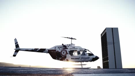 Hubschrauber-Gegen-Sonnenlicht-Landete-Auf-Hubschrauberlandeplatz,-Während-Sich-Der-Rotor-Drehte---Statische-Aufnahme