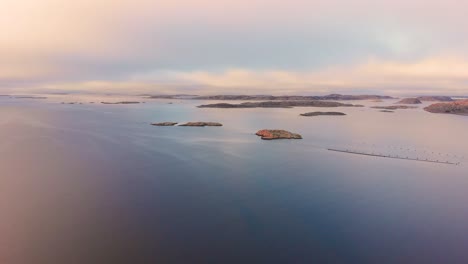 Pequeñas-Islas-Aisladas-Ubicadas-En-Lysekil,-Suecia,-Con-Aguas-Frescas-Y-Tranquilas-Durante-La-Puesta-De-Sol---Toma-Aérea