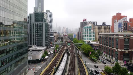 Backwards-Drone-Shot-as-New-York-City-Subway-Train-Enters-Underground-in-Queens,-NYC