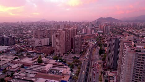 Santiago-at-sunset,-featuring-bustling-cityscape,-aerial-view