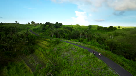 Girl-on-scooter-explores-lush-landscape-of-Teletubbies-Hills,-Nusa-Penida