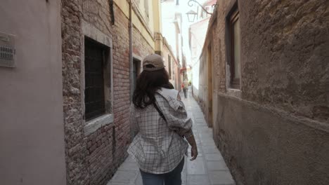 Young-Woman-In-Street-Style-Walking-On-Narrow-Alley-In-Venice,-Italy