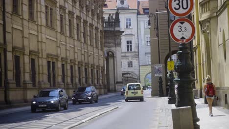 Everyday-traffic-in-Prague-Old-Town,-Czech-Republic-on-a-Sunny-Summer-Day,-Cars,-People-and-Old-Historic-Buildings