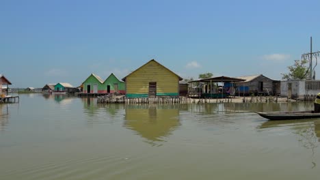 Stilt-houses-and-man-in-canoe-with-kids
