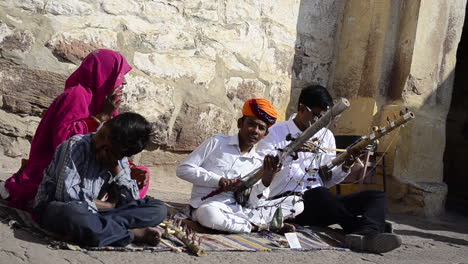 Joven-Cantante-Folclórico-Tradicional-Firmando-Una-Canción-Tocando-El-Violín-En-Público-Con-Su-Familia-Vista-Frontal-Al-Aire-Libre-A-La-Luz-Del-Día