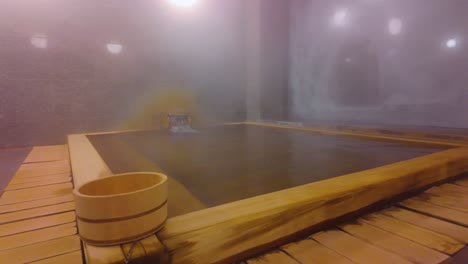 Japan-hot-spring-wooden-bathtub,-geothermal-steam-rising-4k