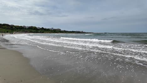 Spaziergang-Am-Strand-An-Einem-Sonnigen-Tag-Mit-Wellen,-Die-Langsam-An-Der-Küste-Brechen,-Rumänien