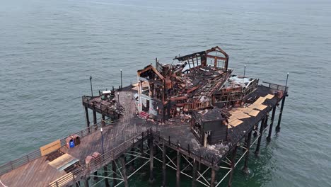 Brandschäden-Am-Oceanside-Pier,-Zerstörung-Des-Ehemaligen-Ruby&#39;s-Diner,-Drohne-Begutachtet-Die-Schäden-Von-Einem-Erhöhten-Kreis-Aus-Gegen-Den-Uhrzeigersinn