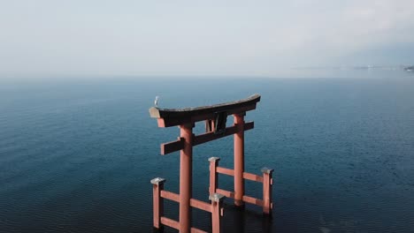 Floating-Torii-with-a-sitting-heron,-Biwa-lake-in-Japan,-slow-motion-24fps-out-of-50fps