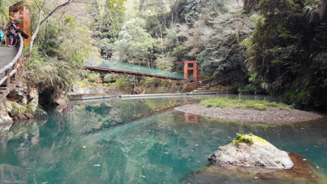 Eine-Drohnenaufnahme-Eines-Teichs-Und-Einer-Hängebrücke-In-Der-Nähe-Des-Songlong-Felswasserfalls-Im-Sun-Link-Sea,-Taiwan