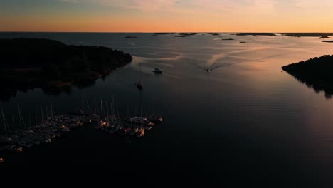 Motorboot-Kommt-In-Der-Marina-Von-Jussaro-An,-Sommersonnenuntergang-In-Finnland---Luftaufnahme