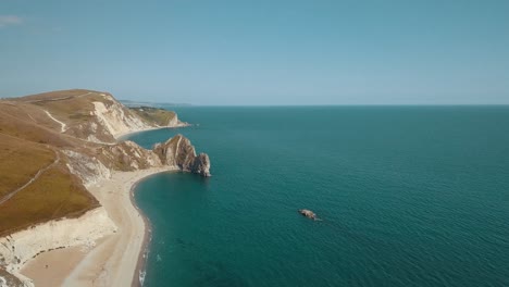 Aerial-shot-flying-sideways-over-impressive-cliffs-towards-sea-on-the-Jurassic-Coast,-Southern-England