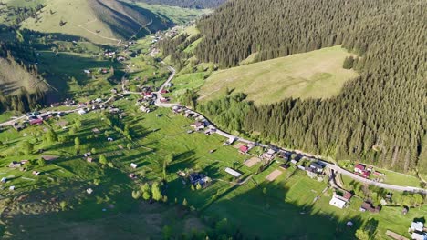 Imágenes-Aéreas-Del-Pueblo-De-Slatioara-En-Rumania,-Que-Muestran-Sus-Casas-Sencillas-Y-El-Pueblo-Ubicado-Entre-Colinas-Cubiertas-De-árboles.